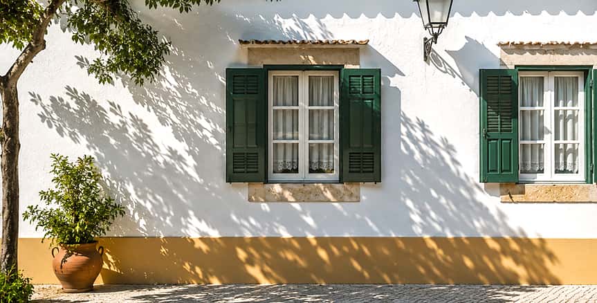 O que faz uma casa parecer fresca no verão: sombra, cores claras e portadas