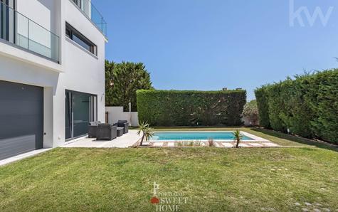 Vista da entrada para a garagem, piscina e jardim