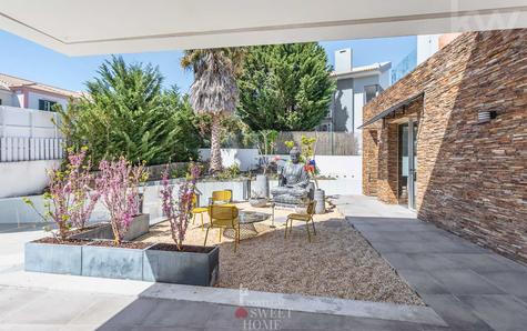 Vista poente da casa com terraço e jardim oriental