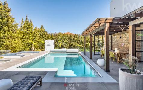 Leisure area with covered swimming pool, dining area with pergola and fire pit.