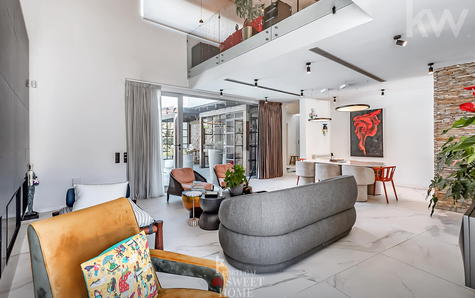 Living room with fireplace, double-height ceiling and mezzanine.