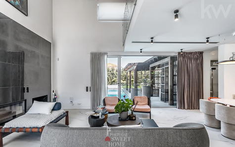 Sala de estar com lareira, duplo pé direito e mezanino